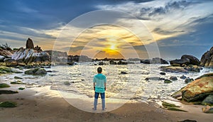 The lonely man watches the sunrise on a sandy beach