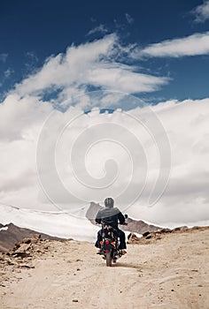 Lonely motocyclist traveler on mountain rosad in Himalaya