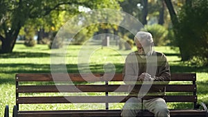 Lonely old man disappearing from bench, concept of death, transience of life photo