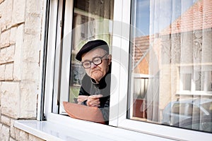 Lonely old man looking out the window