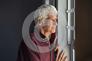 Lonely old man looking out the window