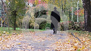A lonely old man walks in an autumn park, his steps were slow and determined. The man is depressed