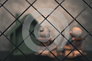 Lonely old man & woman sitting on armchairs behind the fence concept of lonely elder people or quarantine