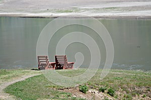 Lonely Pair of Wooden Benches Waiting Patiently Beside the Water
