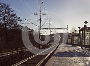 Lonely person on commuter train station a cold, winter morning.