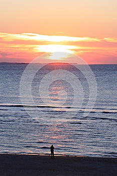 Lonely person looking at sunset, dutch Ameland Island photo