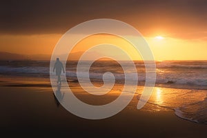 Lonely person walking on beach at sunset