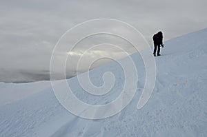Lonely photographer with tripod making winter trekking,Ukraine