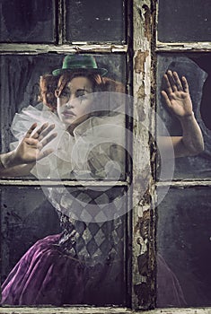 A lonely pierrot woman behind the glass photo