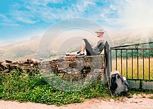 Lonely Pilgrim with backpack resting. Camino de Santiago, Camino del Norte or the Coastal Saint James Way, pilgrimage route along