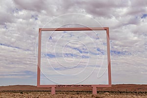 A lonely pink arch stands in the Namib desert against the backdrop of a cloudy sky