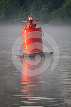 Lonely red buoy in the rays of the rising sun, Don river, Russia