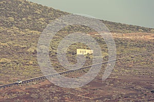 Lonely road crossing arid desolated vulcanic wasteland.