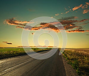 Lonely road leading to the horizon at sunset sky