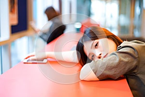 Lonely sad girl looking at nowhere on lying on the table