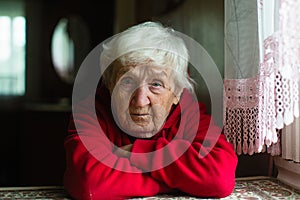 Lonely sad old woman in a red jacket