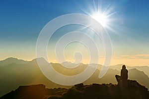 Lonely sad person sitting on mountain