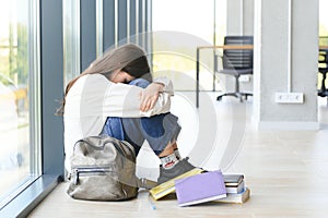 Lonely sad schoolgirl while all her classmates ignored her. Social exclusion problem. Bullying at school concept.