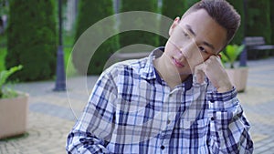 Lonely sad young asian guy of a disabled person in a wheelchair in the park