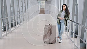 Lonely sad young hispanic woman female passenger tourist stands alone in airport terminal railway station near panoramic