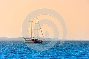 Lonely sailboat sails on the sea at dawn, beautiful landscape