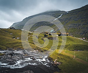 Lonely seaside house between the foggy green mountains, Faroe islands, Saksun village