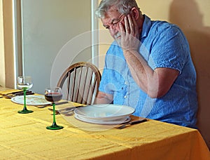 Lonely senior man at the dinner table.