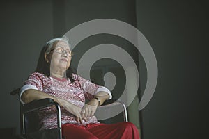 Lonely senior woman looks pensive in a wheelchair
