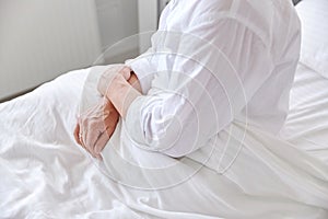 Lonely senior woman sitting in bed at hospital