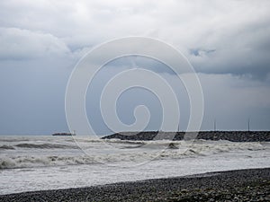 lonely ship in the middle of a rough sea. Barge in the distance. Big waves on the sea. After the storm. Bad weather. Ship on the