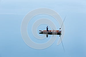 A lonely small boat with two young fishermen