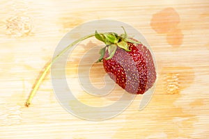 Lonely strawberry on a chopping board