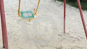 Lonely swing like symbol loneliness and boring. Solitariness empty playground swing on sand.