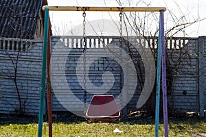 lonely swing standing near the fence