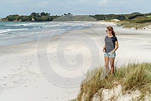 lonely thoughtful woman standing on seashore and looking at sea Rarawa beach