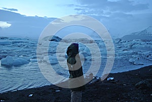 Lonely traveler in the background of waterscape with huge ice floes