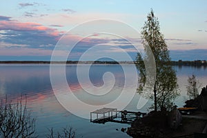 Lonely tree at the old pier. Big lake at sunset of the day.