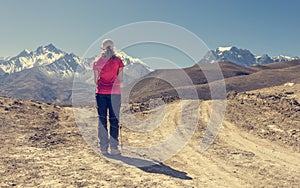 Lonely trekker on a crossroad of two roads towards mountains.