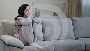 Lonely upset sad muslim young woman sit on sofa health problem interrupted pregnancy divorce islamic unwell girl in