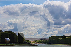 A lonely view of Versailles park, France. The geometric combination of green trees, grass areas and Grand Canal