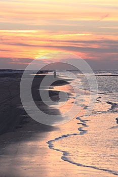 Lonely walker in evening sunlight, Ameland, Holland photo