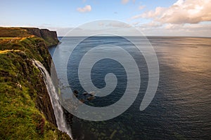 Lonely water fall with cliff and Lush grass in Isle of Skye, Scotland.