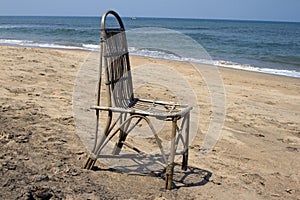 The lonely wattled chair costs on a beach, against the sea. GOA India beach