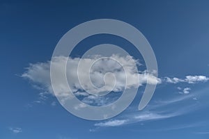 Lonely white cumulus cloud in a blue spring sky. Nature background