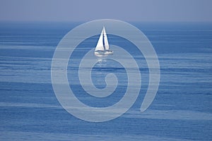 Lonely white sail at infinite ocean