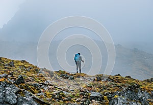 Lonely woman with backpack and trekking poles going by mountain route during Makalu Barun National Park near Tuli Kharka