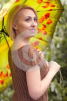 The lonely woman in a beautiful knitted jacket. The beautiful woman on walk. Fashionable clothes.