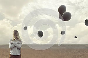 Lonely woman with blacks balloons hid her face