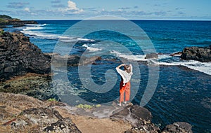 Lonely woman dressed light summer clothes enjoying Indian ocean view with strong surf on cliff at Gris Gris viewpoint extreme photo