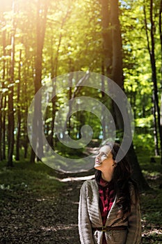 Lonely woman enjoys time in forest on quarantine. Happy girl looking up